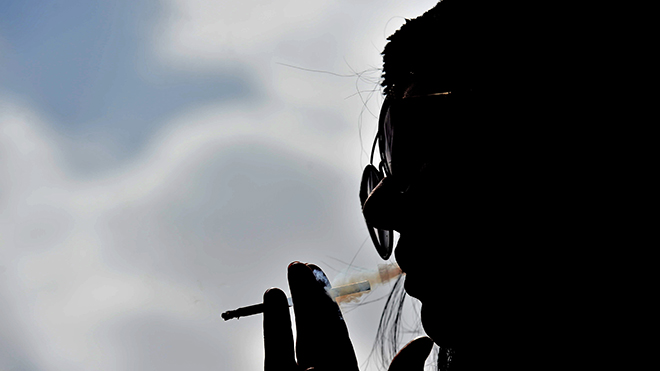 هبة ، امرأة تبلغ من العمر 36 عامًا ، تدخن سيجارة بشكل علني في مقهى في شمال الرياض